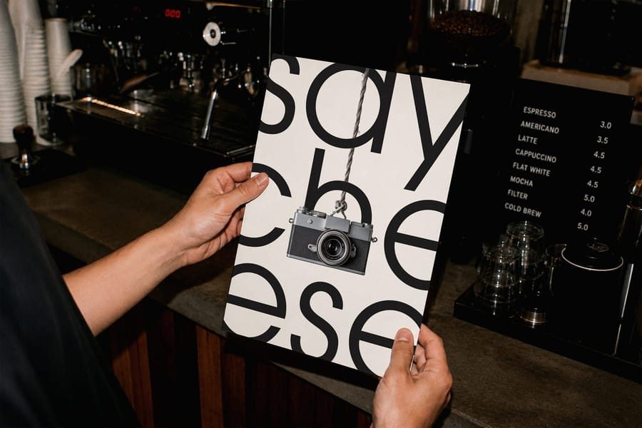 Hand Holding Poster Mockup Coffee Shop Interior Scene