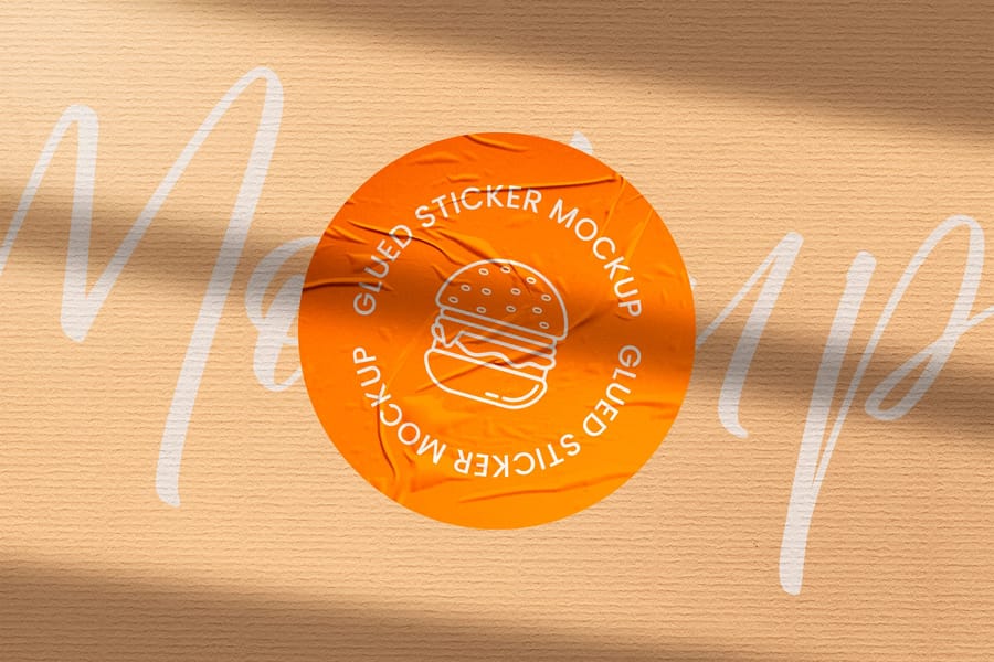 Wrinkled Orange Badge Sticker Mockup with Typography Background